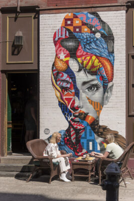 A wall painting, an outdoor place to sit and dine.